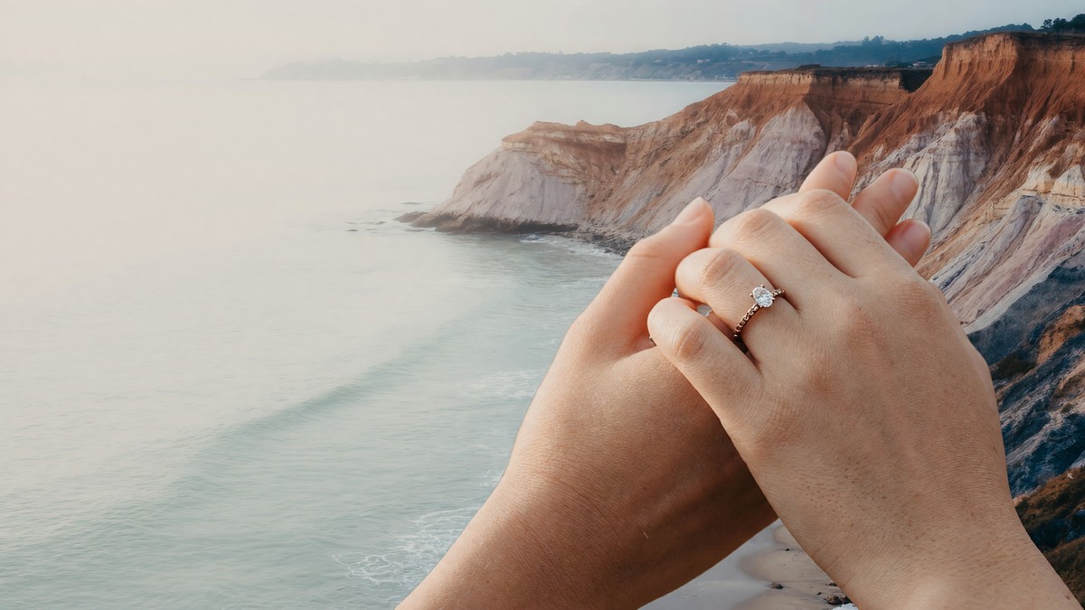 Two hands resting together, one wearing an engagement ring.